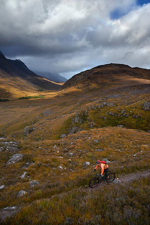 simsearch:649-08900720,k - Male mountain biker biking on dirt track in mountain valley landscape, elevated view,  Achnasheen, Scottish Highlands, Scotland Stock Photo - Premium Royalty-Free, Code: 649-09250276