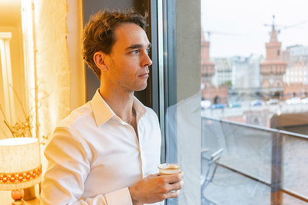 simsearch:649-07238896,k - Mid adult businessman looking through office window while taking coffee break Stock Photo - Premium Royalty-Free, Code: 649-09250320