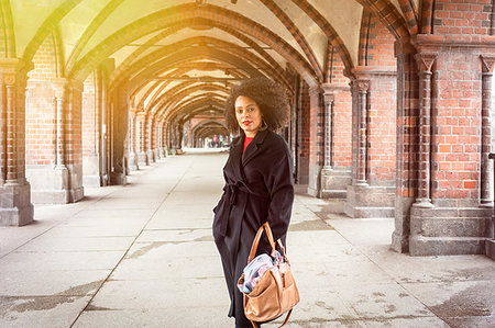 simsearch:649-08922723,k - Mid adult woman in stylish coat under archway of Oberbaum Bridge, portrait, Berlin, Germany Stock Photo - Premium Royalty-Free, Code: 649-09250334