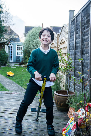 simsearch:649-07648247,k - Boy jumping on pogo stick in garden Stock Photo - Premium Royalty-Free, Code: 649-09250436