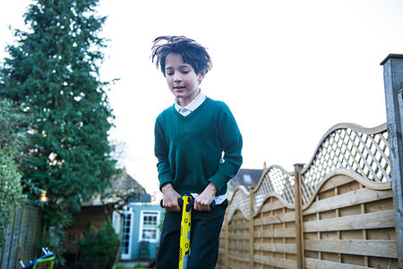 simsearch:649-07648247,k - Boy jumping on pogo stick in garden Stock Photo - Premium Royalty-Free, Code: 649-09250438