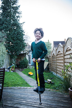 simsearch:649-07648247,k - Boy jumping on pogo stick in garden Stock Photo - Premium Royalty-Free, Code: 649-09250439