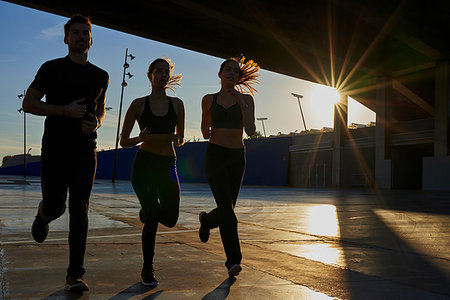 simsearch:649-07520907,k - Friends jogging in sports stadium at sunset Stock Photo - Premium Royalty-Free, Code: 649-09250801