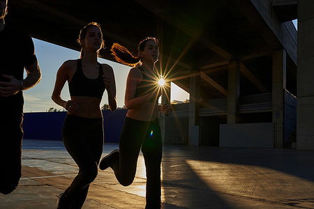 simsearch:649-07520907,k - Friends jogging in sports stadium at sunset Stock Photo - Premium Royalty-Free, Code: 649-09250802