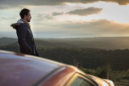 Man resting against car on roadside, enjoying view on hilltop Stock Photo - Premium Royalty-Free, Code: 649-09250926