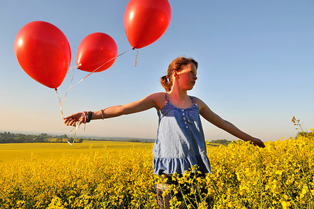 simsearch:649-07437432,k - Girl with red balloons on rapeseed field, Eastbourne, East Sussex, United Kingdom Stock Photo - Premium Royalty-Free, Code: 649-09251476