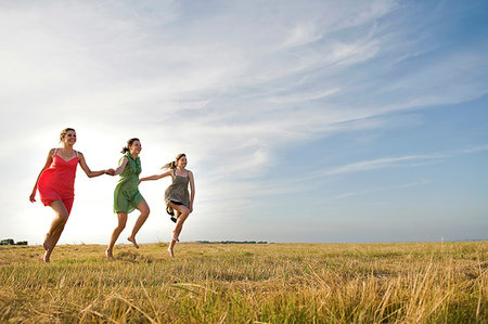 simsearch:649-07437432,k - Girlfriends skipping on field, Eastbourne, East Sussex, United Kingdom Stock Photo - Premium Royalty-Free, Code: 649-09251471