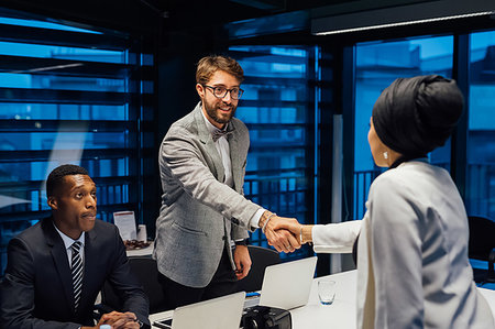 simsearch:649-07238396,k - Businessman and female client shaking hands over conference table meeting Stock Photo - Premium Royalty-Free, Code: 649-09251610
