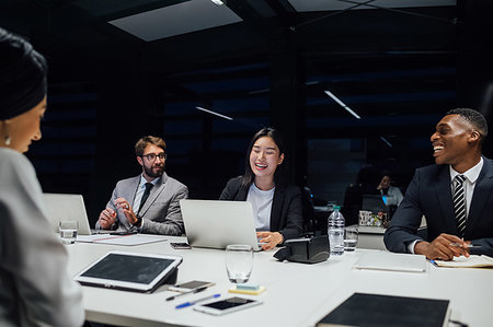 simsearch:649-07238396,k - Businesswomen and men laughing during conference table meeting Stock Photo - Premium Royalty-Free, Code: 649-09251639