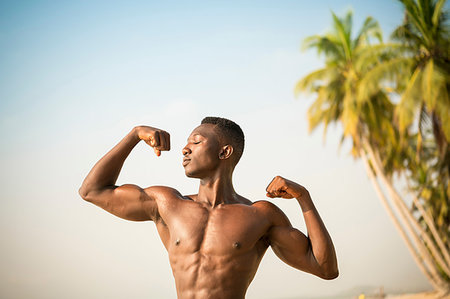 simsearch:693-05552857,k - Man flexing arm muscles on beach Stock Photo - Premium Royalty-Free, Code: 649-09251982