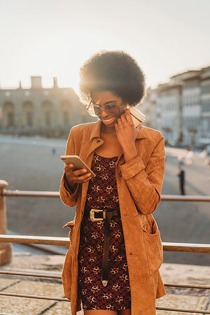 Young woman with afro hair having hot drink, using smartphone in city, Florence, Toscana, Italy Stock Photo - Premium Royalty-Free, Code: 649-09268499