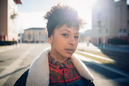 Cool young woman with nose piercing on sunlit urban sidewalk, head and shoulder portrait Foto de stock - Sin royalties Premium, Código: 649-09268907