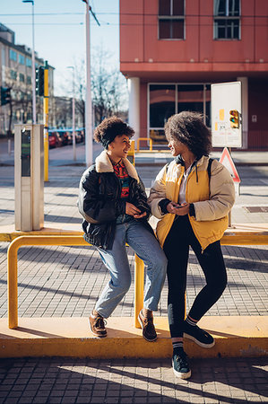 Two cool young women chatting at city tram station Stock Photo - Premium Royalty-Free, Code: 649-09268941