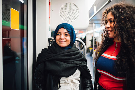 Young woman in hijab and friend on subway train Stock Photo - Premium Royalty-Free, Code: 649-09269052