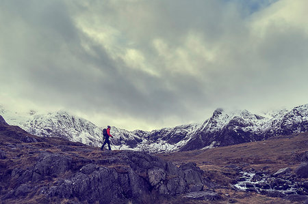simsearch:649-08085723,k - Male hiker hiking across rugged landscape with snow capped mountains, Llanberis, Gwynedd, Wales Foto de stock - Sin royalties Premium, Código: 649-09269109