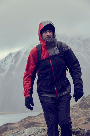 simsearch:649-08085723,k - Male hiker looking up while hiking in snow capped mountains with storm clouds, Llanberis, Gwynedd, Wales Foto de stock - Sin royalties Premium, Código: 649-09269124