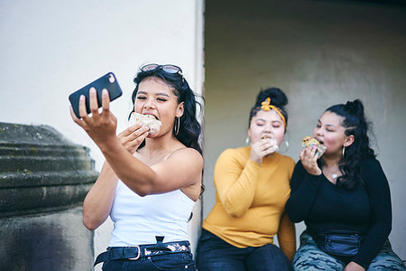 simsearch:649-07736862,k - Young woman taking selfie with teenage sisters while eating cakes in doorway Stock Photo - Premium Royalty-Free, Code: 649-09275610