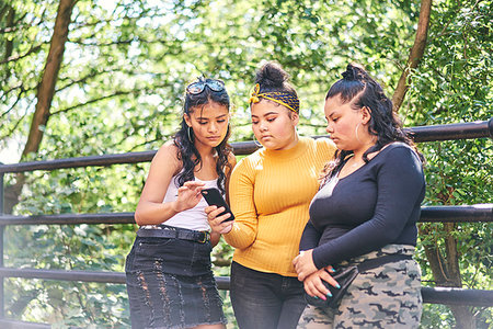 simsearch:649-07736862,k - Young woman with teenage sisters looking at smartphone in park Stock Photo - Premium Royalty-Free, Code: 649-09275624