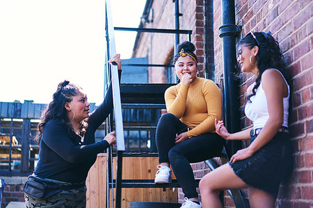 simsearch:649-07736862,k - Young woman and her teenage sisters chatting on fire escape Stock Photo - Premium Royalty-Free, Code: 649-09275630