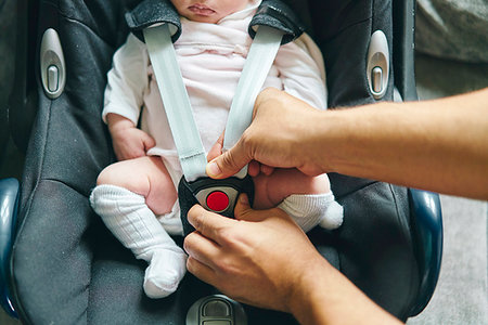 simsearch:632-08001820,k - Father buckling up baby in baby cradle Stock Photo - Premium Royalty-Free, Code: 649-09275895
