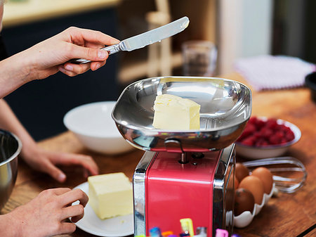 simsearch:614-06897440,k - Girl and her sister baking a cake, weighing butter on kitchen scales, cropped view of hands Stock Photo - Premium Royalty-Free, Code: 649-09276189