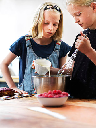 simsearch:614-06897440,k - Girl and her sister baking a cake, pouring cream into mixing bowl at kitchen table Stock Photo - Premium Royalty-Free, Code: 649-09276203