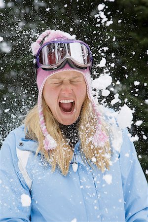 exploding (human temper) - Snowball exploding on young blonde woman wearing ski-wear in forest Stock Photo - Premium Royalty-Free, Code: 649-01556076