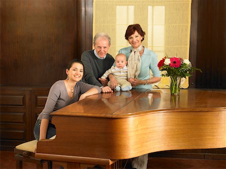 Multigenerational family (grandparents, mother and baby son (7months) by grand piano, portrait. Alicante, Spain. Stock Photo - Premium Royalty-Free, Code: 649-01556839