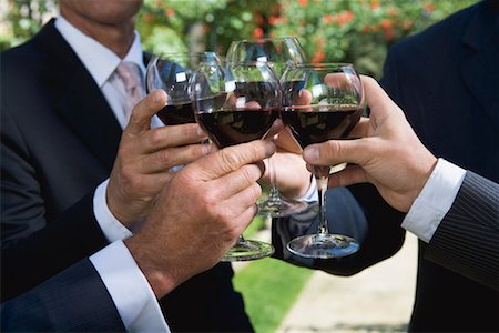 Four businessmen drinking wine in a garden Stock Photo - Premium Royalty-Free, Code: 649-01608497