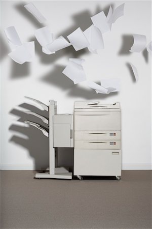 A photocopier against a white wall with paper flying out. Stock Photo - Premium Royalty-Free, Code: 649-01610604