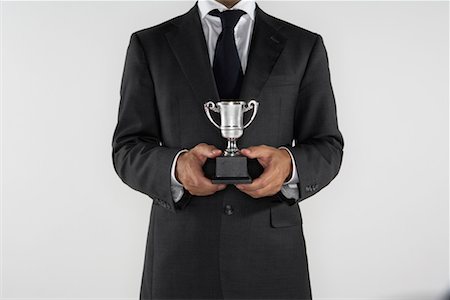 simsearch:693-06325208,k - Man holding a small silver trophy. Stock Photo - Premium Royalty-Free, Code: 649-01610639