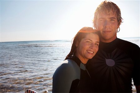 simsearch:649-01696405,k - Couple standing on beach with surfboard. Stock Photo - Premium Royalty-Free, Code: 649-01695897
