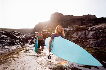 simsearch:649-01696512,k - Four people carrying surfboards in the water smiling. Stock Photo - Premium Royalty-Free, Code: 649-01695934