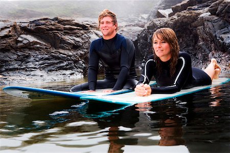 simsearch:649-01696405,k - Couple lying on surfboards in the water smiling. Stock Photo - Premium Royalty-Free, Code: 649-01695994