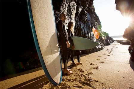 simsearch:649-01696405,k - Couple standing with surfboards by large rocks. Stock Photo - Premium Royalty-Free, Code: 649-01696029
