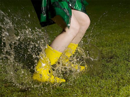 Woman jumping in rain puddle Stock Photo - Premium Royalty-Free, Code: 649-02055270