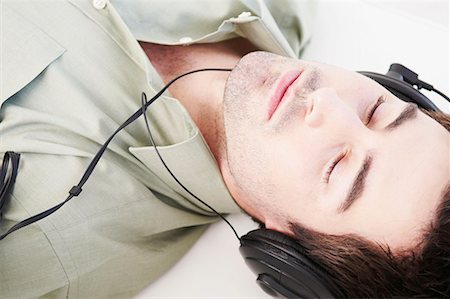 Reclined male relaxes with headphones Stock Photo - Premium Royalty-Free, Code: 649-02055383