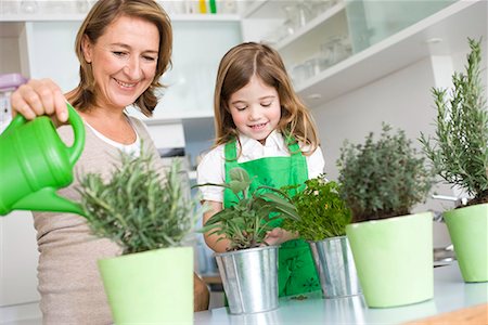 Daughter and mother watering herbs Stock Photo - Premium Royalty-Free, Code: 649-02053921