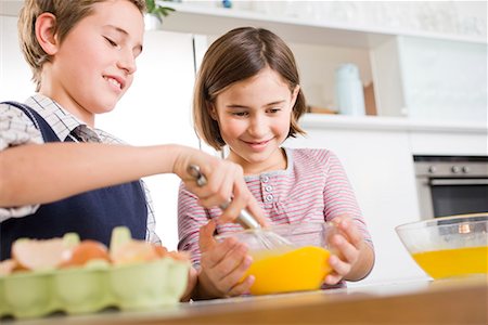 friends cooking inside - Boy and girl stirring egg yolk together Stock Photo - Premium Royalty-Free, Code: 649-02053952