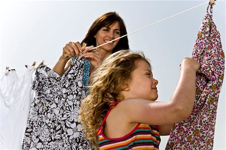 Girl helping mother hang clothes Stock Photo - Premium Royalty-Free, Code: 649-02198888