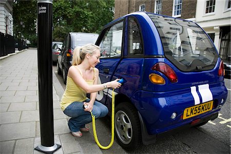 plugging in - Young woman charging electric car Stock Photo - Premium Royalty-Free, Code: 649-02424171