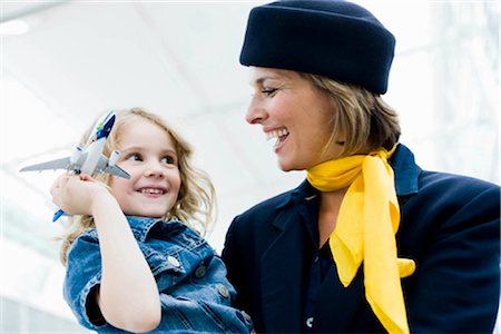 Stewardess holding child in her arms Stock Photo - Premium Royalty-Free, Code: 649-02423625