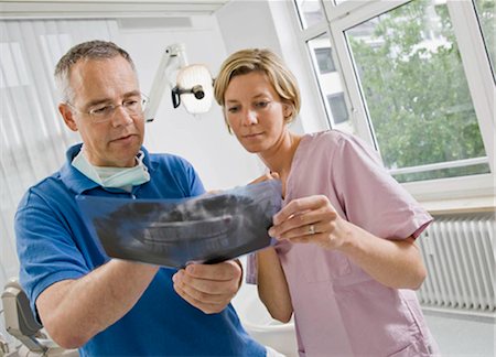Dentist and assistant looking at x-rays Stock Photo - Premium Royalty-Free, Code: 649-02665298