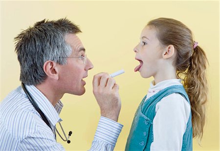 sticking out - A doctor checks a girls throat Stock Photo - Premium Royalty-Free, Code: 649-02666316