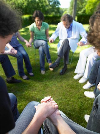 doctor giving medicine to adult patient - Circle of people in rehab, holding hands Stock Photo - Premium Royalty-Free, Code: 649-02731684