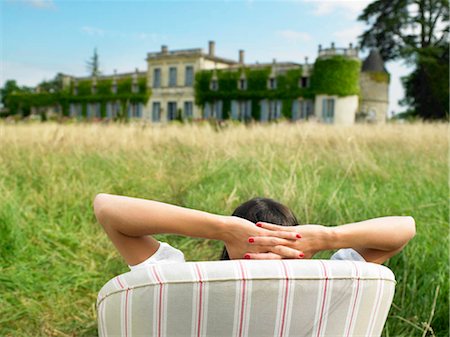 estate - Woman on sofa in a field,  castle view Stock Photo - Premium Royalty-Free, Code: 649-02731727
