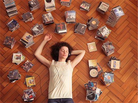 Woman lying on floor,listening to music Stock Photo - Premium Royalty-Free, Code: 649-03009486