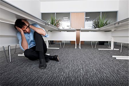 straining (overexertion) - man hiding under desk Foto de stock - Sin royalties Premium, Código: 649-03154107