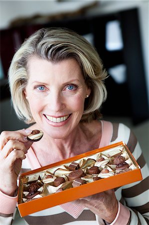 Senior Woman Eating Chocolates Stock Photo - Premium Royalty-Free, Code: 649-03153669
