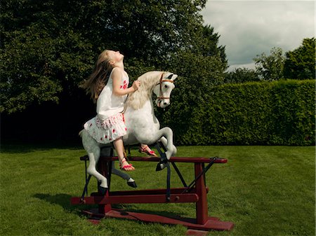 A young girl on a rocking horse Stock Photo - Premium Royalty-Free, Code: 649-03294362